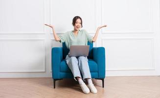 image of young Asian girl sitting on sofa at home photo