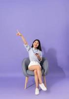 image of girl sitting on sofa  isolated on purple background photo