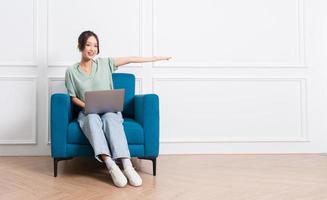 image of young Asian girl sitting on sofa at home photo