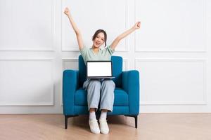 image of young Asian girl sitting on sofa at home photo