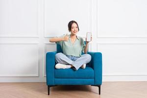 image of young Asian girl sitting on sofa at home photo