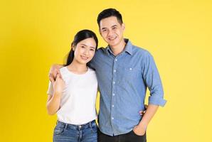 imagen de una pareja asiática posando sobre fondo amarillo foto