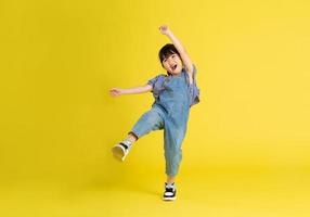 full body image of beautiful asian baby girl on yellow background photo