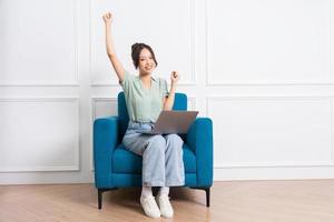 image of young Asian girl sitting on sofa at home photo
