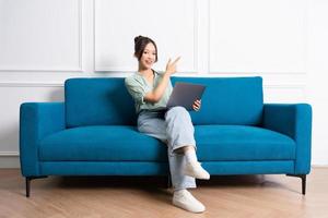 image of young Asian girl sitting on sofa at home photo