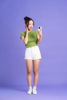 full body image of beautiful asian girl posing on pink background photo