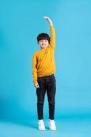 full body image of asian boy posing on blue background photo