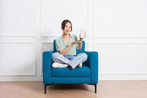 image of young Asian girl sitting on sofa at home photo