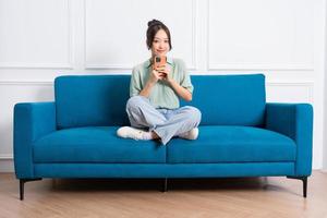 image of young Asian girl sitting on sofa at home photo