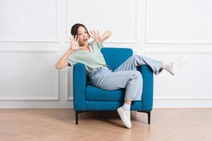 image of young Asian girl sitting on sofa at home photo