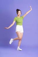 full body image of beautiful asian girl posing on pink background photo