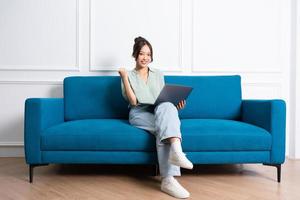 image of young Asian girl sitting on sofa at home photo