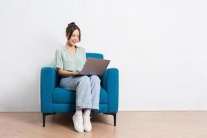image of young Asian girl sitting on sofa at home photo