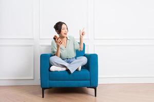 image of young Asian girl sitting on sofa at home photo