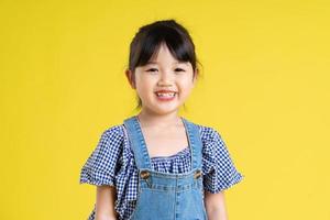 retrato de una hermosa chica asiática, aislada de fondo amarillo foto