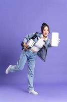 retrato de un hermosa asiático Chica de escuela vistiendo un mochila en un púrpura antecedentes foto