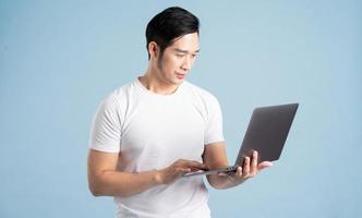 portrait of asian man posing on blue background photo