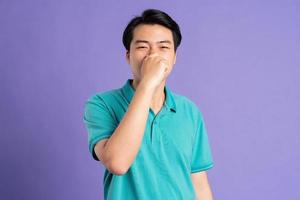 retrato de asiático hombre posando en púrpura antecedentes foto