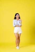 full body image of beautiful asian girl, isolated on yellow background photo