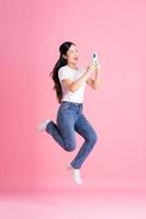 imagen de cuerpo completo de una chica asiática posando sobre fondo rosa foto