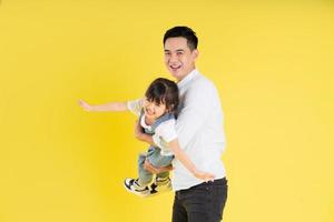 image of two happy father and daughter playing, isolated on yellow background photo