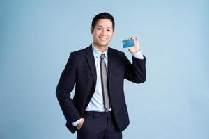 retrato, de, asiático, hombre de negocios, llevando, traje, en, fondo azul foto