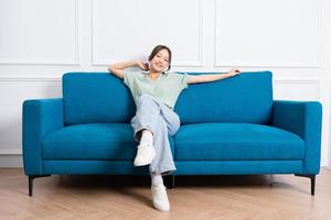 image of young Asian girl sitting on sofa at home photo