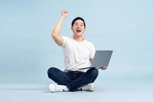 portrait of asian man posing on blue background photo