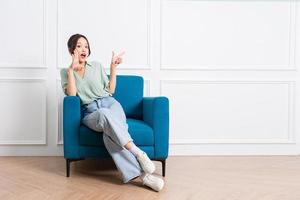 image of young Asian girl sitting on sofa at home photo