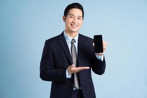 portrait of asian businessman wearing suit on blue background photo