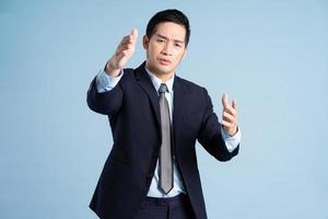 portrait of asian businessman wearing suit on blue background photo