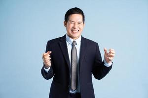 portrait of asian businessman wearing suit on blue background photo