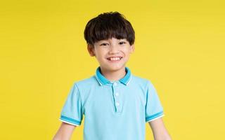 retrato de un asiático chico posando en un amarillo antecedentes foto