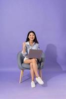 image of girl sitting on sofa  isolated on purple background photo