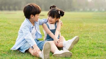 image of brother and sister having fun in the park photo