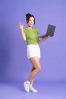 full body image of beautiful asian girl posing on pink background photo