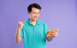 portrait of asian man posing on purple background photo