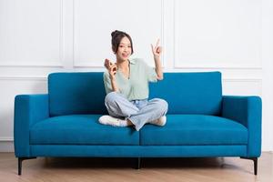 image of young Asian girl sitting on sofa at home photo