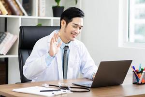 Asian male doctor portrait sitting at work photo