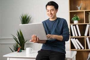 image of Asian man sitting at home working photo