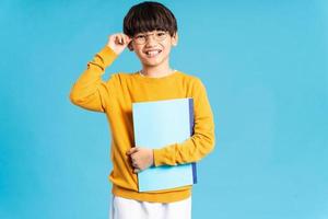 Portrait of Asian school boy born on a blue background photo