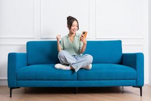 image of young Asian girl sitting on sofa at home photo