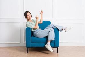 image of young Asian girl sitting on sofa at home photo