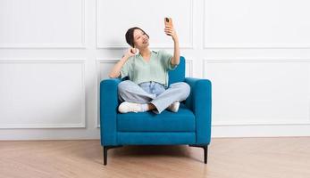 image of young Asian girl sitting on sofa at home photo