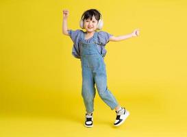 imagen de cuerpo completo de una hermosa niña asiática con fondo amarillo foto