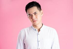 portrait of asian man posing on pink background photo