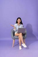 image of girl sitting on sofa  isolated on purple background photo