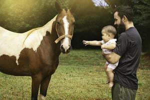 padre y hija siguiente a un caballo foto