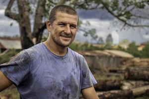 hombre trabajando en un aserradero sonriente y mirando a el cámara foto