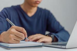 learning online class by using laptop computer and writing notebook at workplace, Education development or knowledge improvement concept. photo